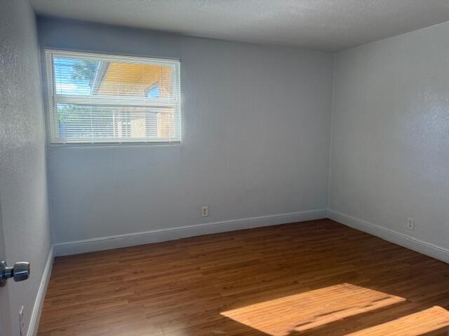 2840 Avenue S A Riviera Beach, Unit 3 Riviera Beach, FL 33404 - Photo 18 of 23 a view of an empty room with wooden floor and a window