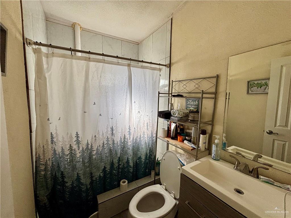 209 Rafael Street Sullivan City, TX 78595 - Photo 11 of 15 a bathroom with a sink a toilet and shower