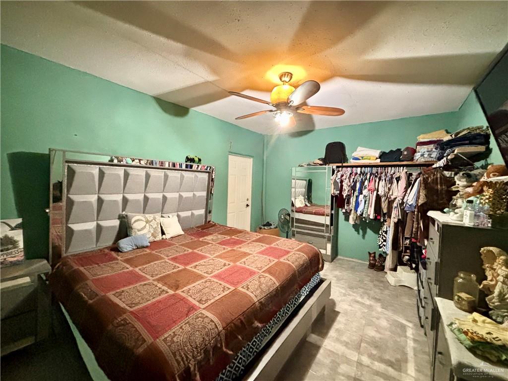 209 Rafael Street Sullivan City, TX 78595 - Photo 9 of 15 a bedroom with a bed and a chandelier