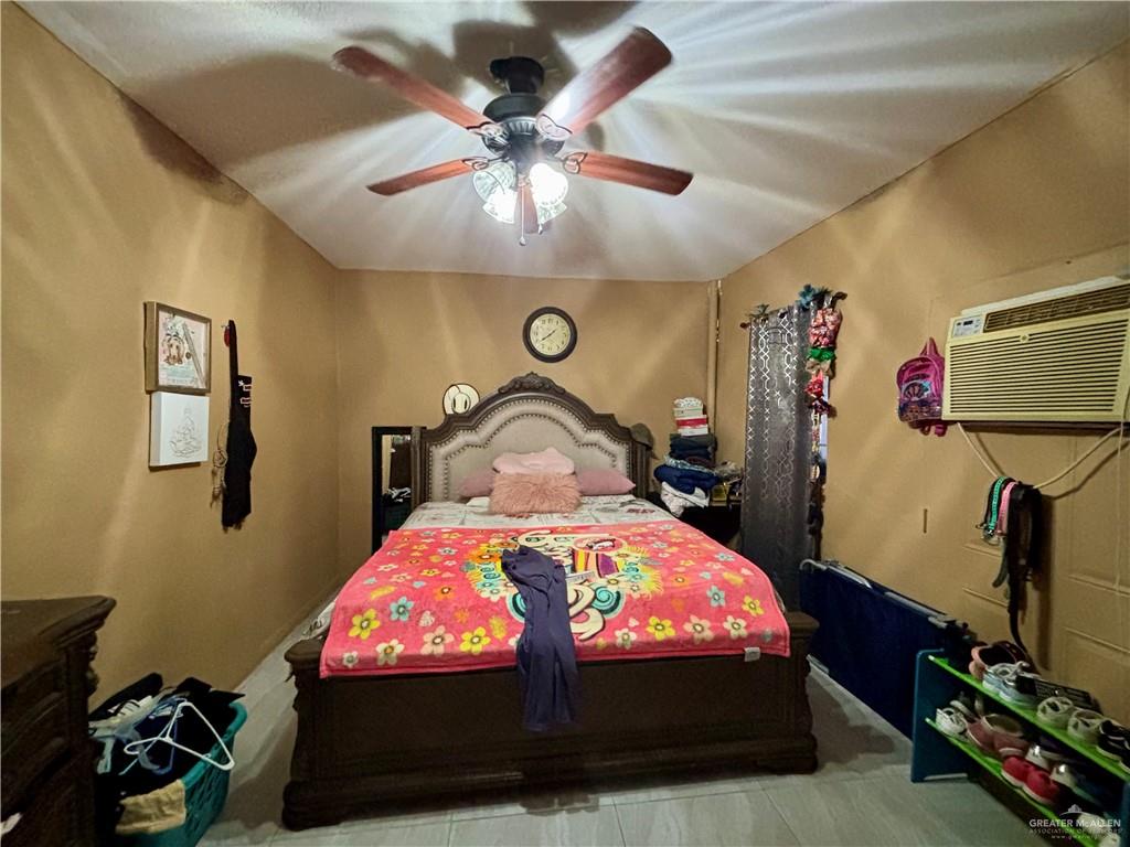 209 Rafael Street Sullivan City, TX 78595 - Photo 10 of 15 a bedroom with a bed and a chandelier
