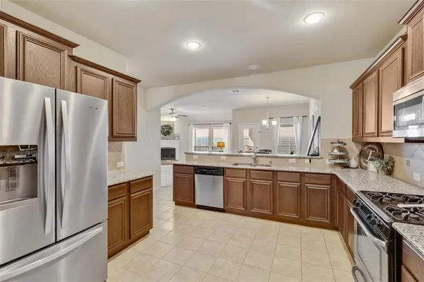 a kitchen with stainless steel appliances granite countertop a stove top oven a sink and dishwasher