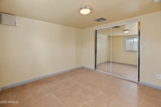 an empty room with windows and closet