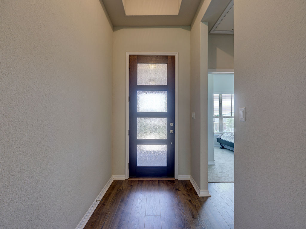 229 Heartleaf Road San Marcos, TX 78666 - Photo 8 of 40 A welcoming entry hall with hardwood flooring and a stylish front door featuring privacy glass.