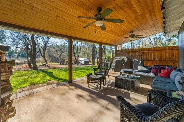 a view of a patio with table and chairs potted plants with wooden floor and fence