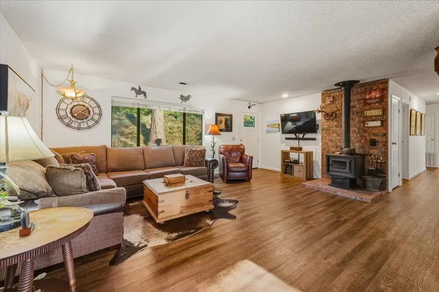 a living room with furniture kitchen view and a wooden floor
