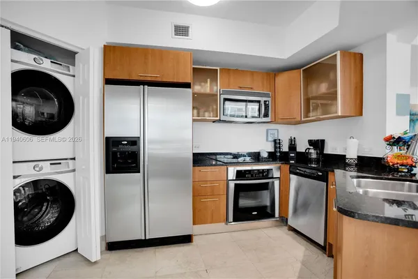 a kitchen with stainless steel appliances granite countertop a stove a sink and a refrigerator