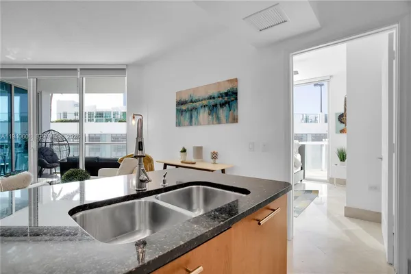 a kitchen with a sink and a large mirror