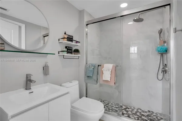 a bathroom with a sink a toilet and shower