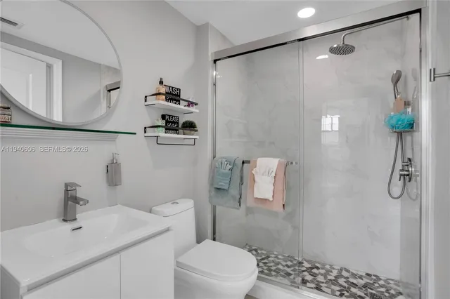 a bathroom with a sink a toilet and shower