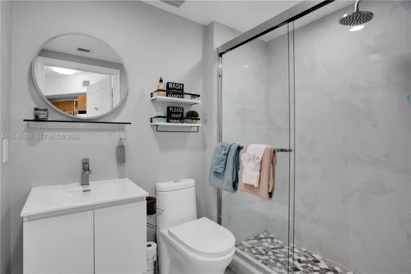 a bathroom with a toilet a sink and mirror