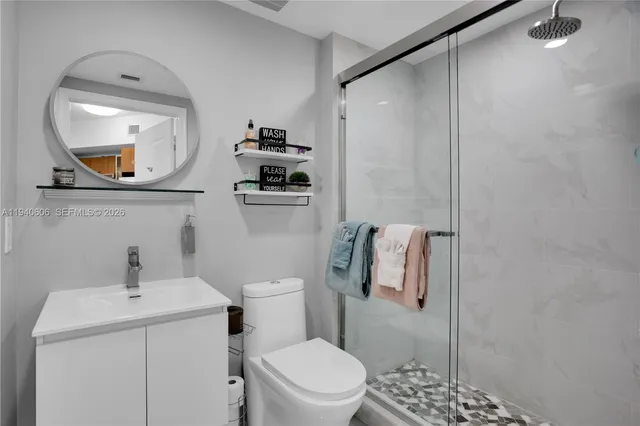 a bathroom with a toilet a sink and mirror