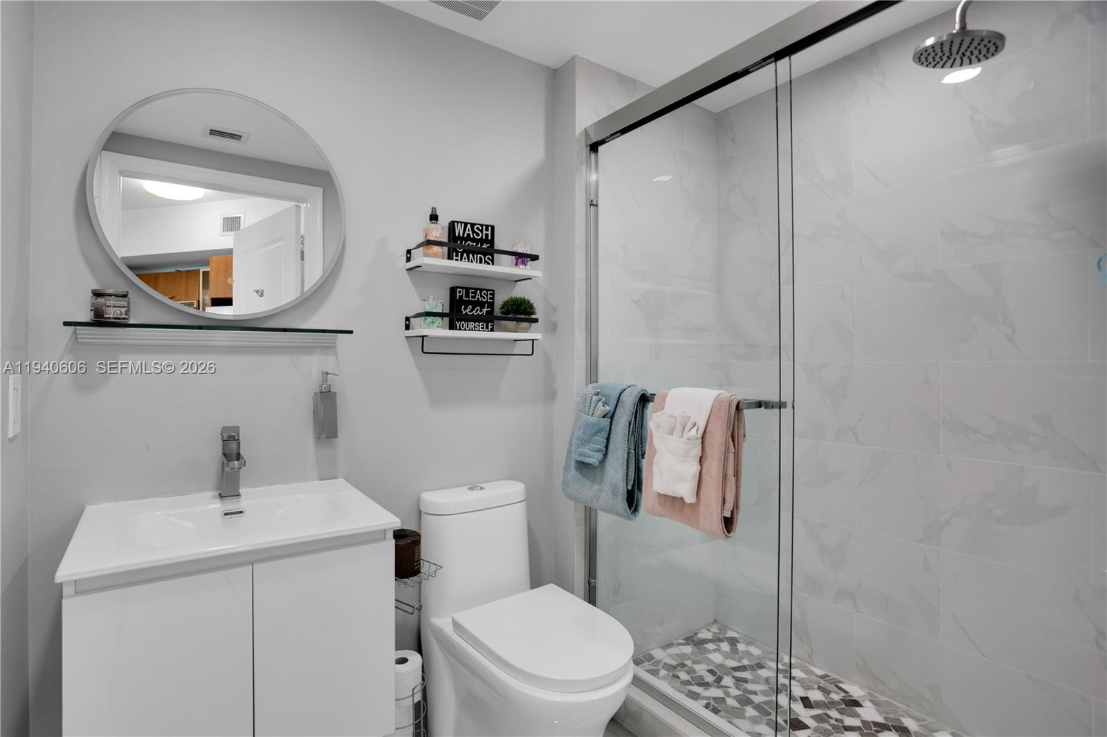 480 Northeast 30th Street, Unit 705 Miami, FL 33137 - Photo 18 of 32 a bathroom with a toilet a sink and mirror