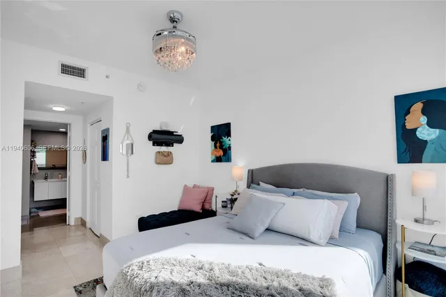 a bedroom with a bed and a chandelier