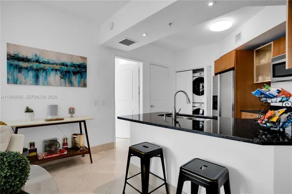 a kitchen with stainless steel appliances kitchen island a table and chairs in it