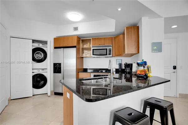 a kitchen with stainless steel appliances granite countertop a stove a sink a microwave and cabinets