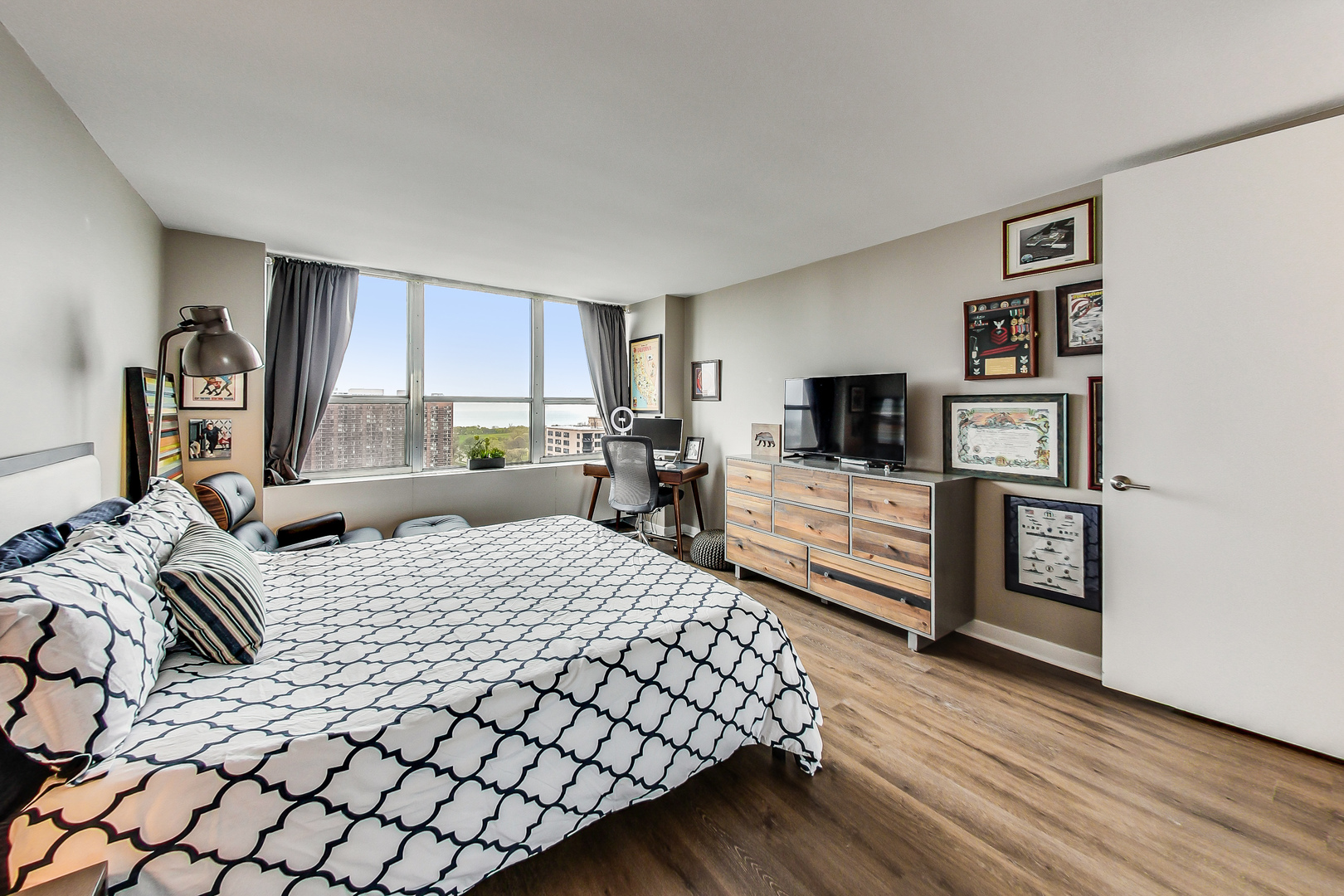 655 West Irving Park Road, Unit 2210 Chicago, IL 60613 - Photo 12 of 38 a large bedroom with a bed and flat tv screen on a dresser