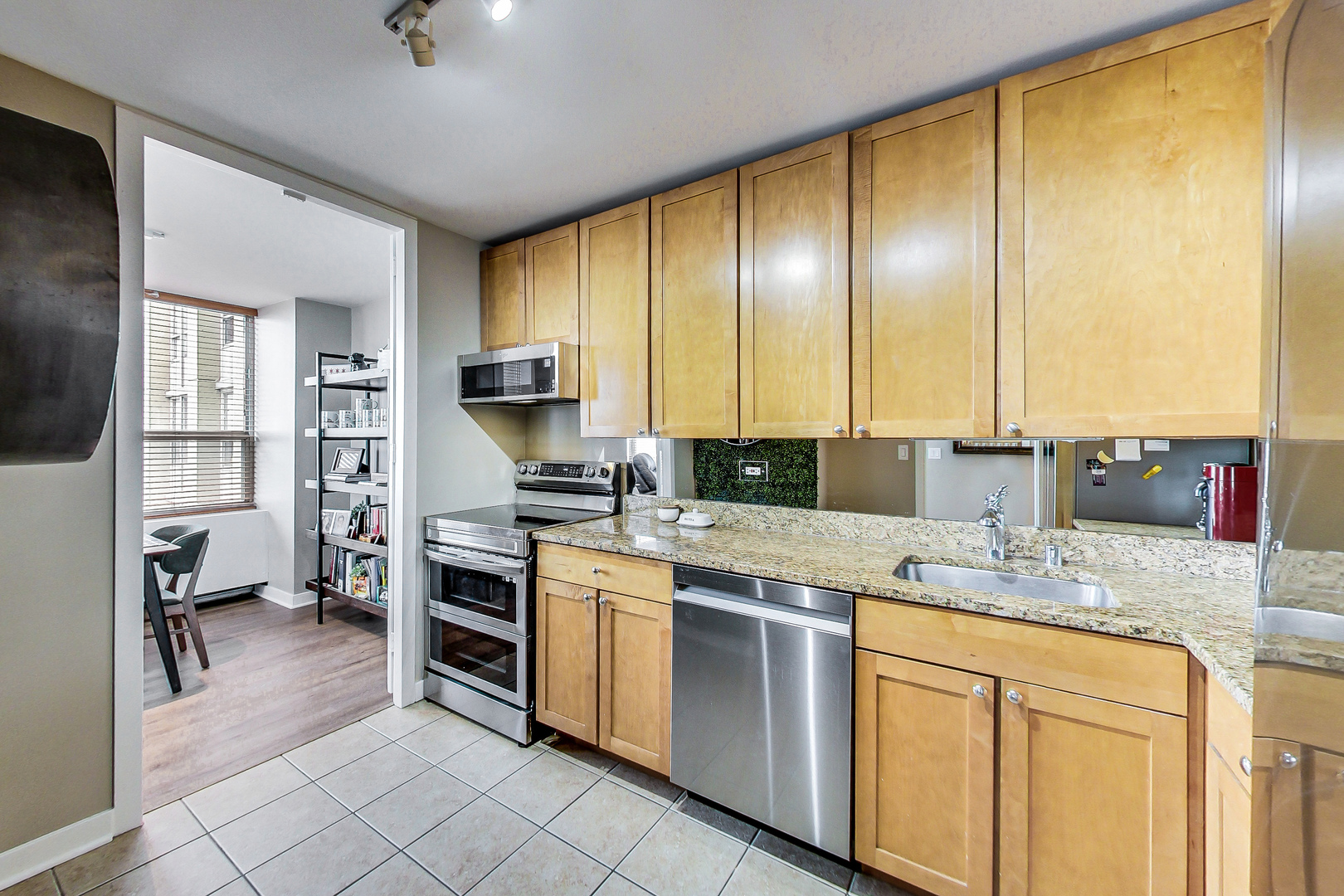 655 West Irving Park Road, Unit 2210 Chicago, IL 60613 - Photo 8 of 38 a kitchen with stainless steel appliances granite countertop a sink counter space cabinets and a window