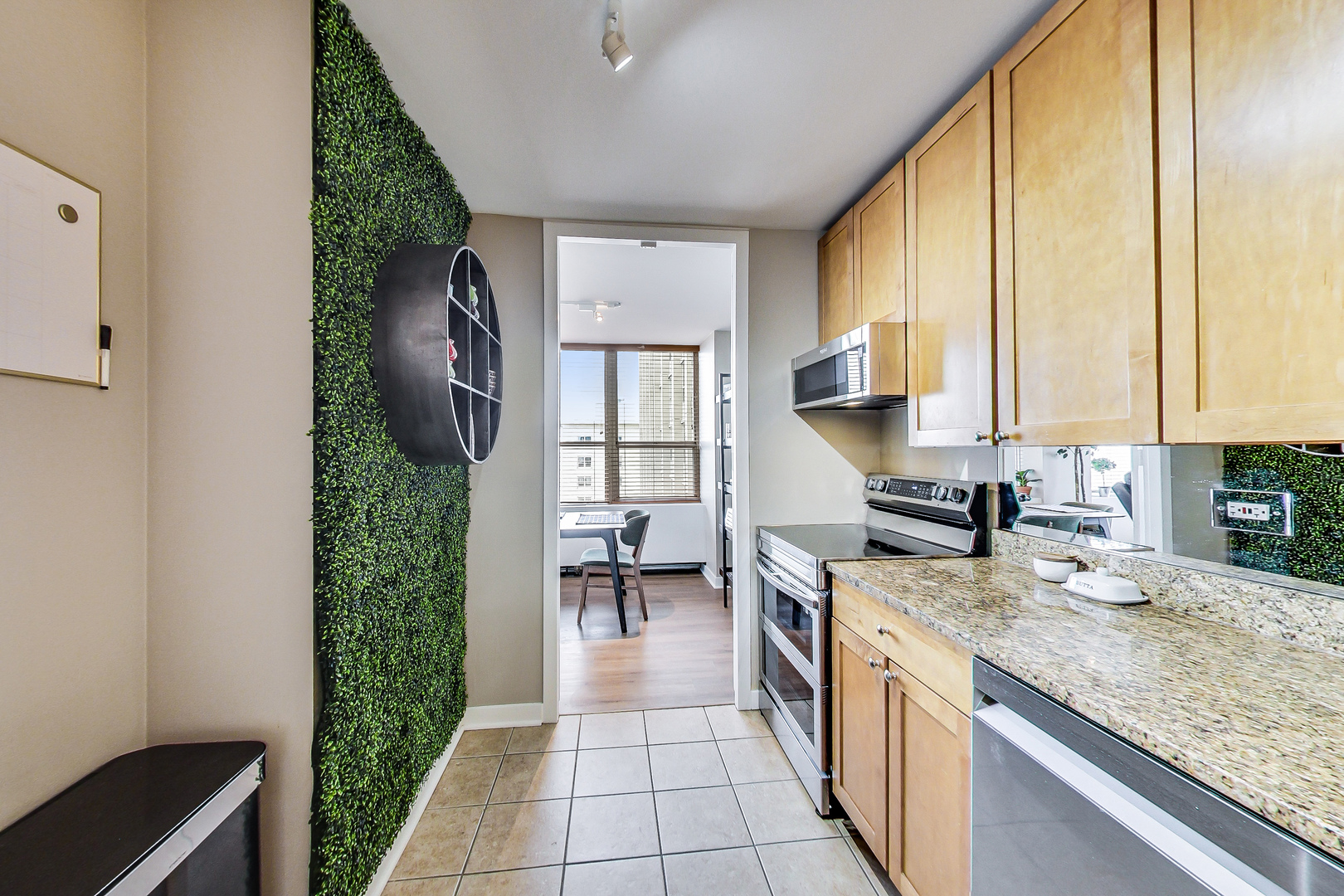 655 West Irving Park Road, Unit 2210 Chicago, IL 60613 - Photo 10 of 38 a kitchen with granite countertop a stove a sink and a refrigerator