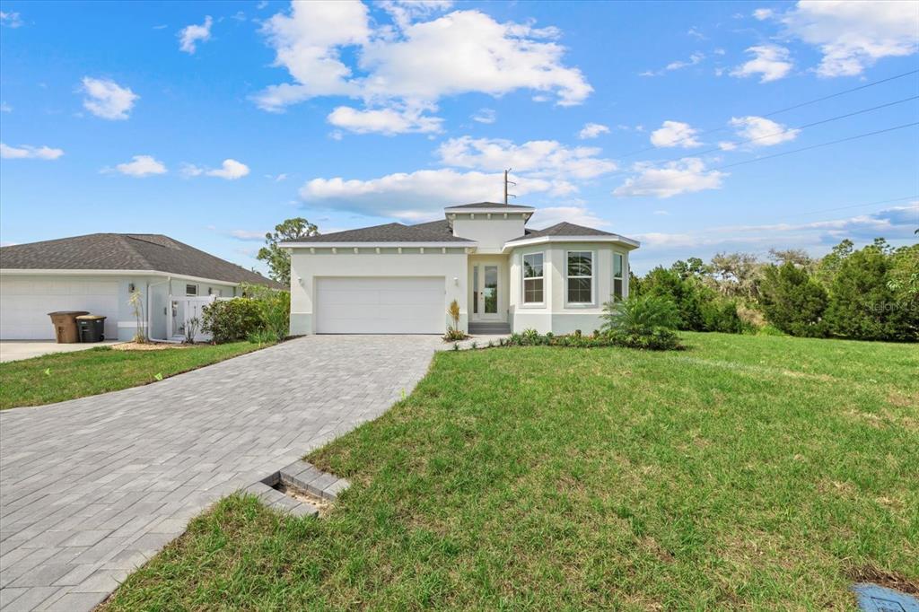 7443 South Seagrape Road Punta Gorda, FL 33955 - Photo 37 of 44 a front view of a house with a yard and garage