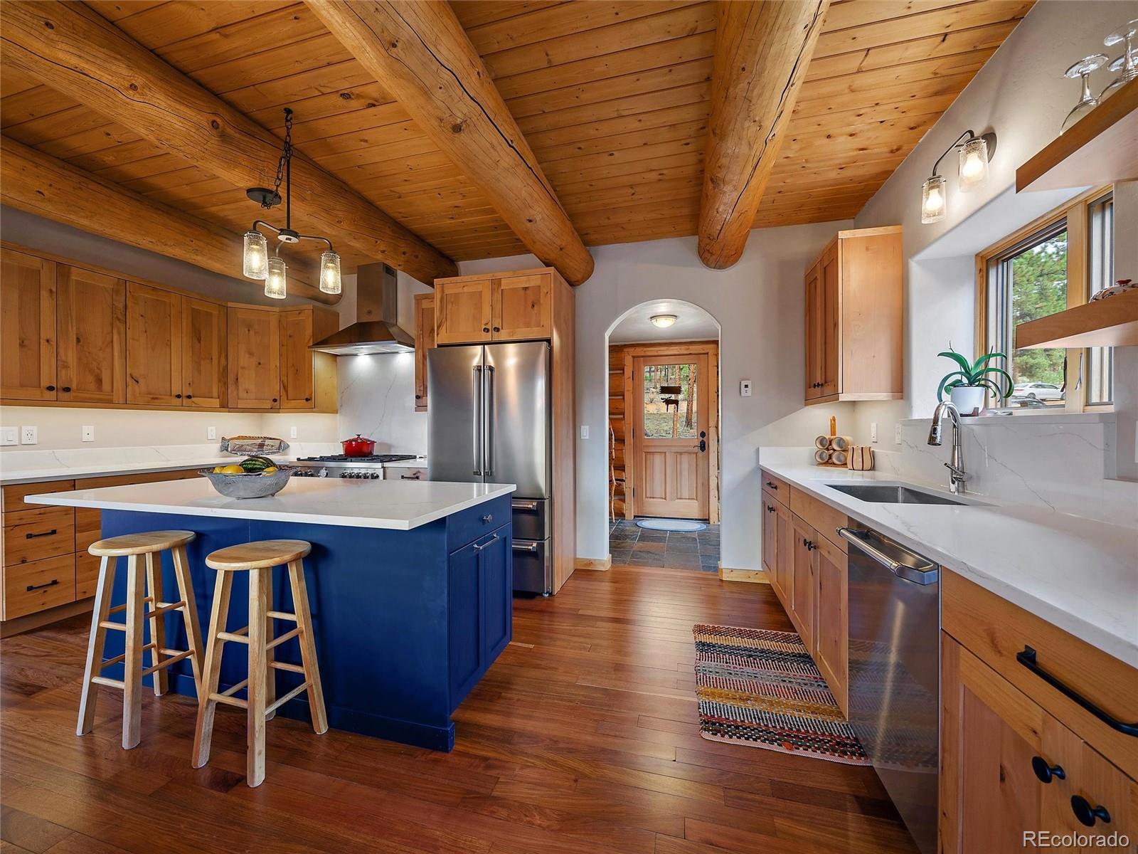 96 Six Bits Street Bailey, CO 80421 - Photo 14 of 40 a large kitchen with wooden cabinets and stainless steel appliances