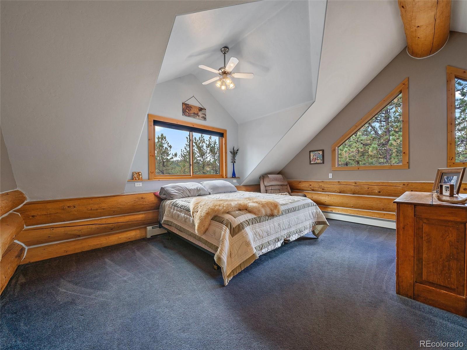 96 Six Bits Street Bailey, CO 80421 - Photo 28 of 40 a spacious bedroom with a bed and a large window