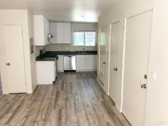 a kitchen with granite countertop a refrigerator and a stove