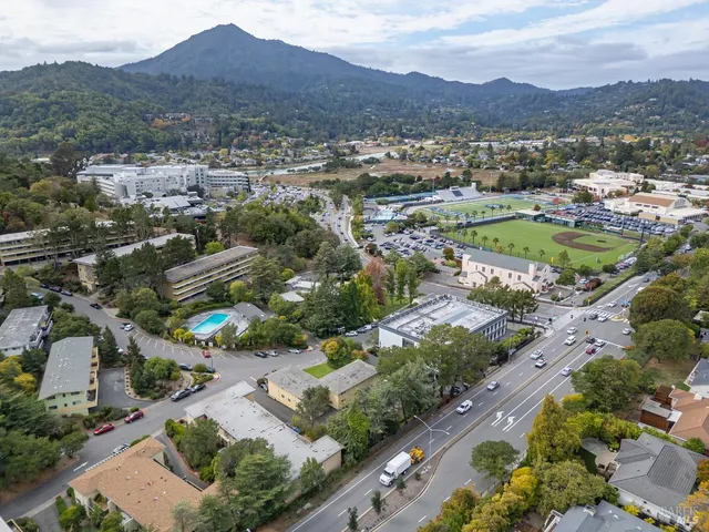 an aerial view of a city with lots of residential buildings and mountain view in back