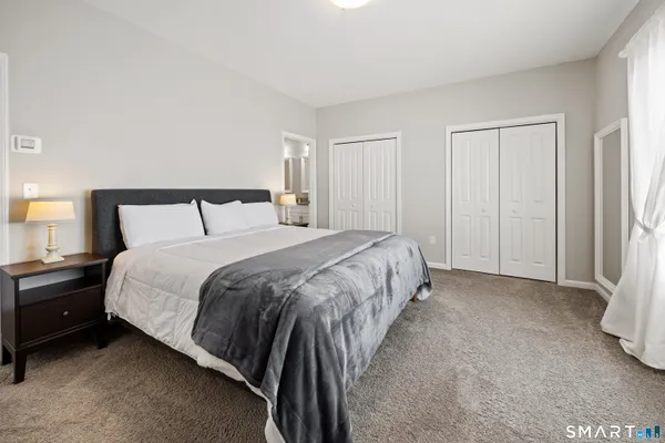 a bed sitting in a bedroom next to a lamp