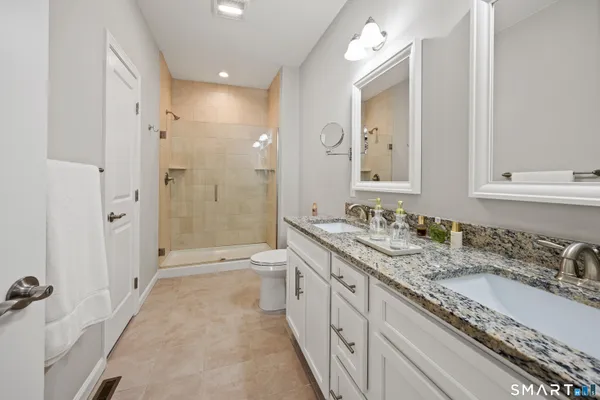 a spacious bathroom with a granite countertop sink mirror and shower