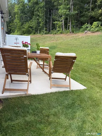a backyard of a house with table and chairs