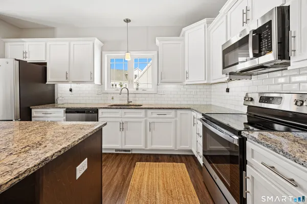 a kitchen with stainless steel appliances granite countertop a sink stove and refrigerator