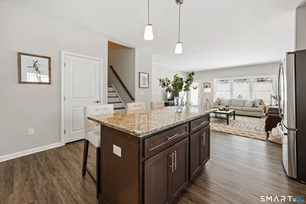 a kitchen with stainless steel appliances granite countertop a kitchen island a stove and a wooden floors