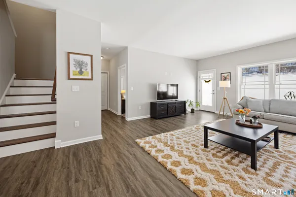 a living room with furniture and wooden floor