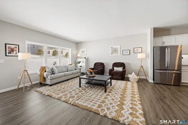 a living room with furniture rug and wooden floor