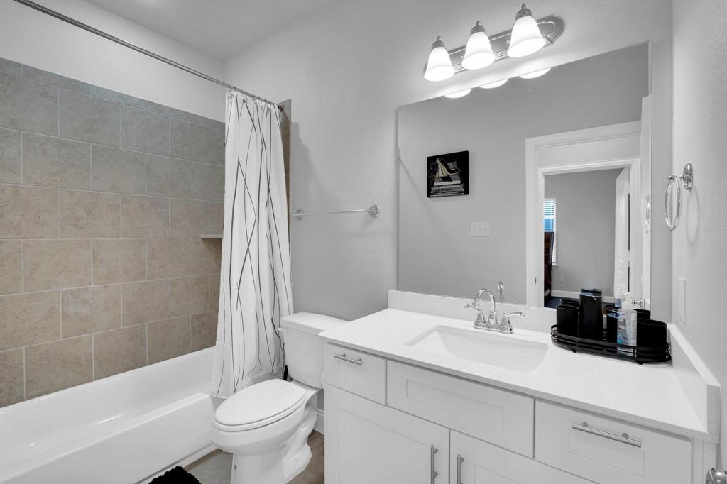 1498 Weston Road Dallas, TX 75234 - Photo 20 of 24 Full bathroom featuring a white vanity with integrated sink, a large mirror, and a three-light fixture