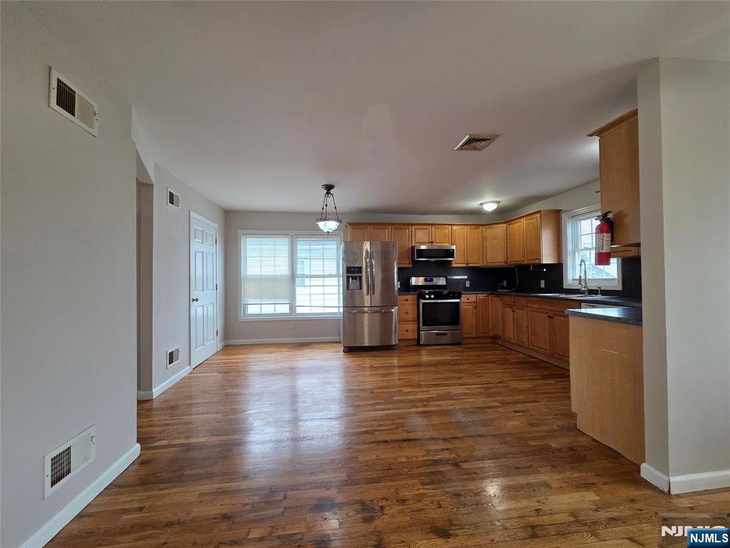 22 Broadway, Unit 2 Hackensack, NJ 07601 - Photo 2 of 11 a living room with stainless steel appliances kitchen island granite countertop a stove and a refrigerator