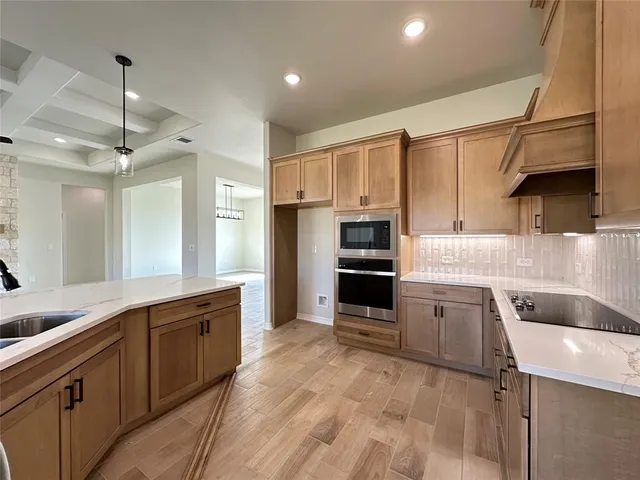 a large kitchen with granite countertop a refrigerator oven a sink and dishwasher