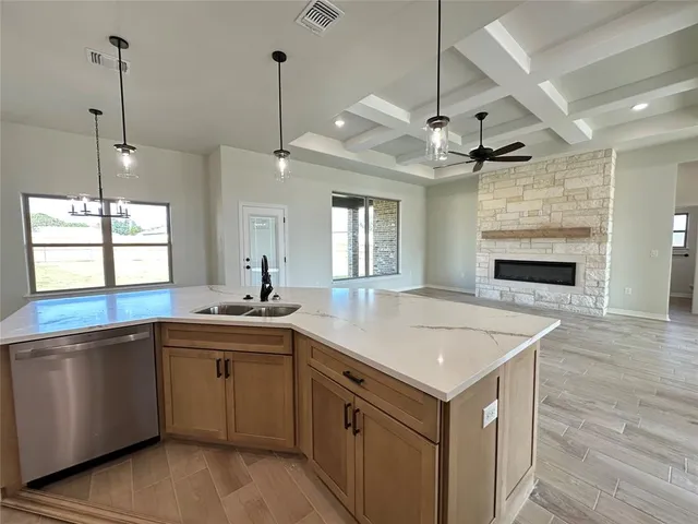 a kitchen with a sink stove and wooden floor