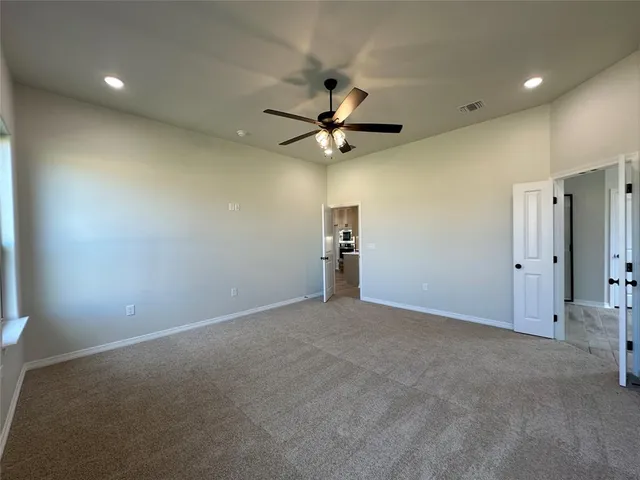 a view of an empty room with a ceiling fan