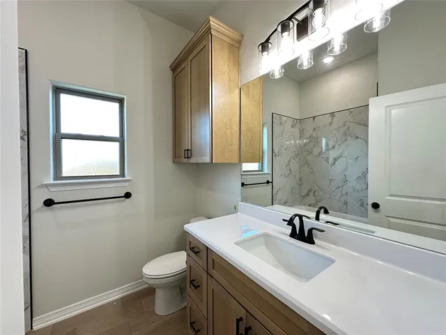 a bathroom with a sink toilet and shower