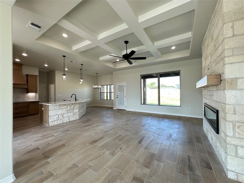 403 Rusty Spur Lorena, TX 76655 - Photo 7 of 29 a view of an empty room and kitchen with fireplace wooden floor and windows