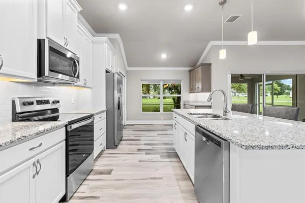 a large kitchen with stainless steel appliances granite countertop a stove and a sink