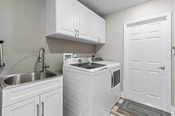 a utility room with sink dryer and washer