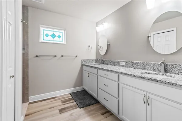 a spacious bathroom with a granite countertop sink mirror and vanity