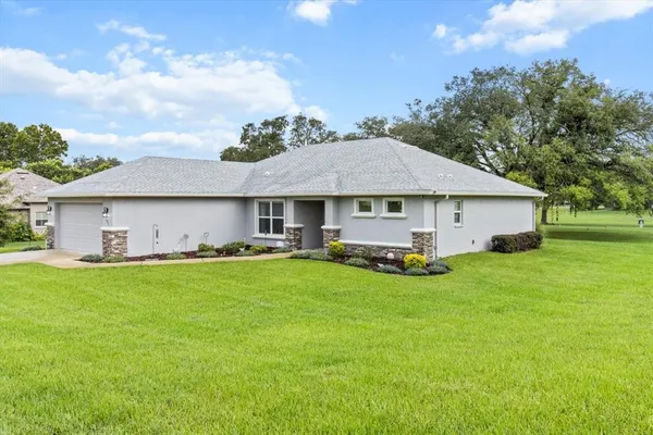 a view of a house with a yard and sitting area