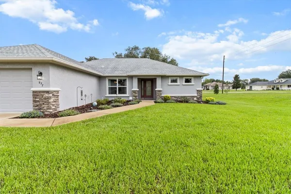 a front view of a house with a garden and yard