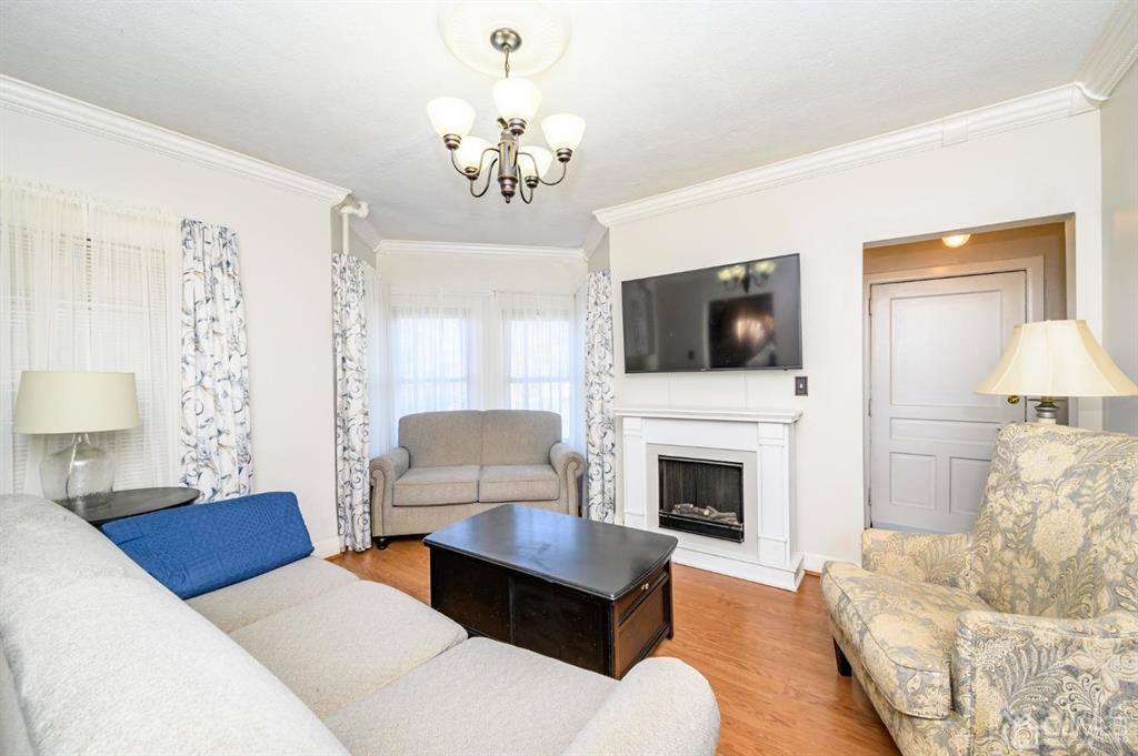 105 New Market Road Dunellen, NJ 08812 - Photo 12 of 39 a living room with furniture a fireplace and a flat screen tv
