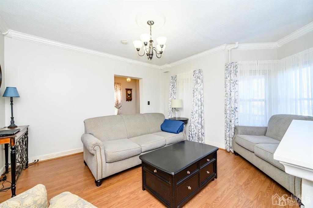 105 New Market Road Dunellen, NJ 08812 - Photo 15 of 39 a living room with furniture and a chandelier