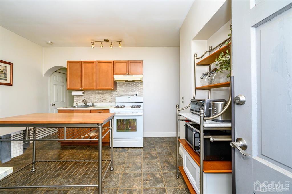 105 New Market Road Dunellen, NJ 08812 - Photo 3 of 39 a room with stainless steel appliances a stove and cabinets