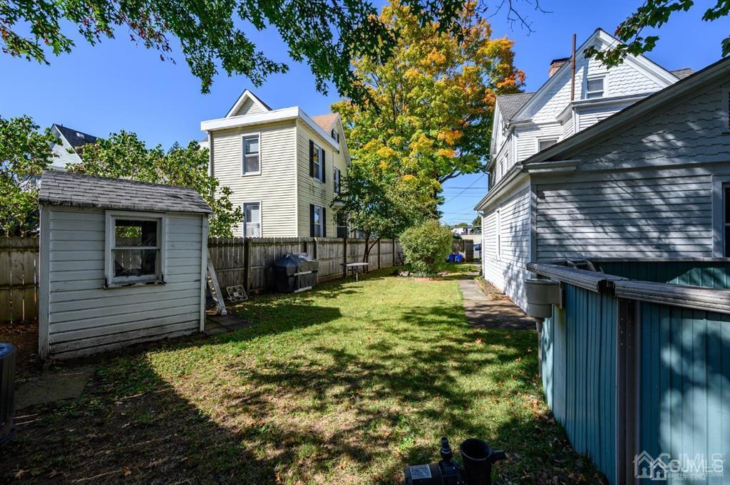105 New Market Road Dunellen, NJ 08812 - Photo 38 of 39 a backyard of a house with plants and brick wall